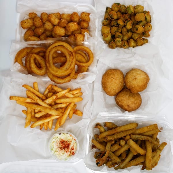 An overhead shot of various fried foods including fries, onion rings, tater tots, fried okra, and hush puppies.