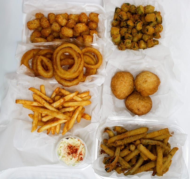 An overhead shot of various fried foods including fries, onion rings, tater tots, fried okra, and hush puppies.