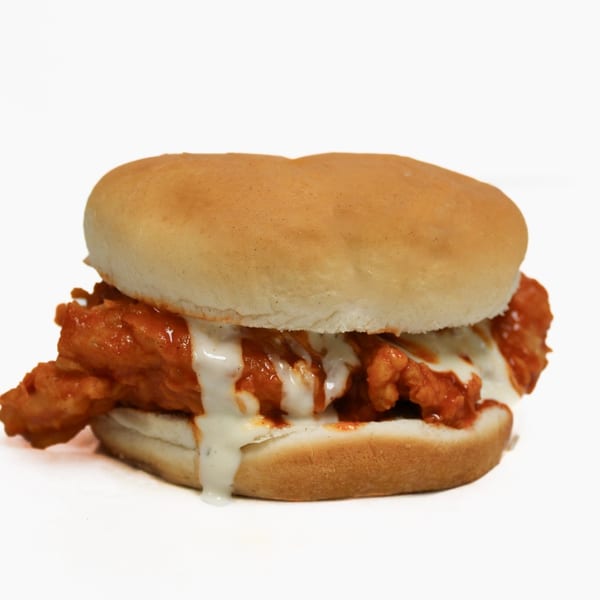 Buffalo chicken sandwich with melted cheese and ranch dressing on a white bun.